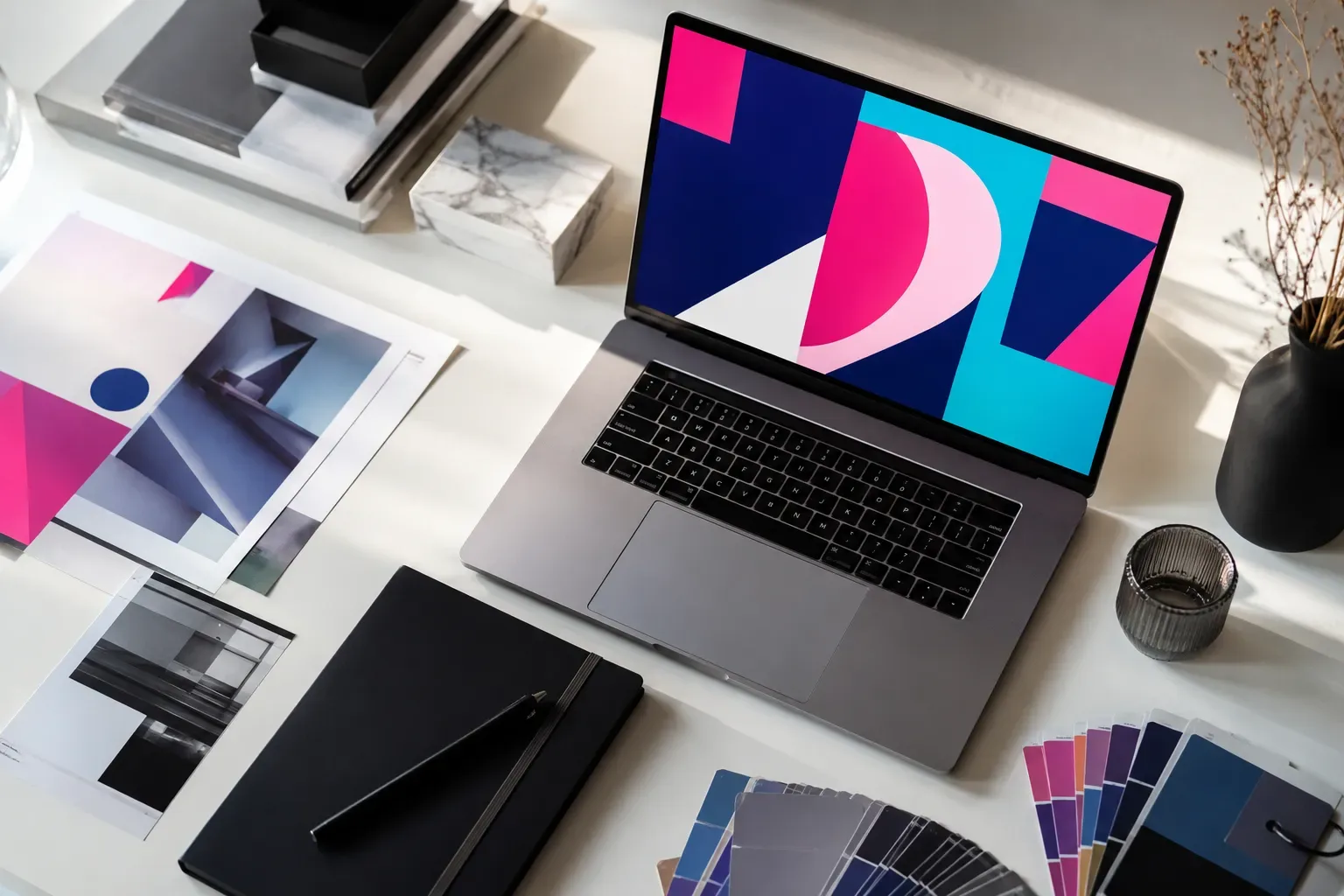 Ontwerptafel met tekentablet, kleurstalen en een laptop